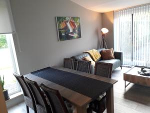 a living room with a table and a couch at Het Innerhof in Opglabbeek