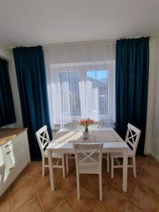 jadalnia ze stołem i krzesłami oraz oknem w obiekcie Apartamenty Kolorowa w Szczyrku