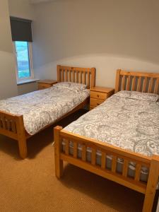 two twin beds in a room with a window at The moorings in Belmullet