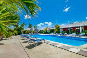 een zwembad met ligstoelen en een resort bij Aruba Blue Village Hotel and Apartments in Palm-Eagle Beach