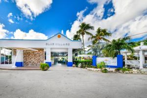 a building at the beach with palm trees at Aruba Blue Village Hotel and Apartments in Palm-Eagle Beach