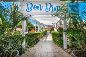 una señal para una tienda de jardinería con plantas y una pasarela en Aruba Blue Village Hotel and Apartments en Palm-Eagle Beach