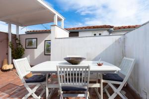 einen weißen Tisch und Stühle auf einer Terrasse in der Unterkunft Attico Sesto Canto in Palermo