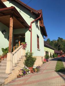 a building with stairs and flowers in front of it at Tünde Vendégház in Viştea