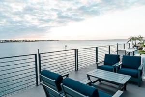 a balcony with chairs and a table and water at The Suites at Fishermen's Village - 2 Bedroom Suites in Punta Gorda