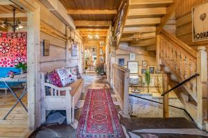 a living room with wooden stairs and a couch at Leśniczówka u Zięby in Witów