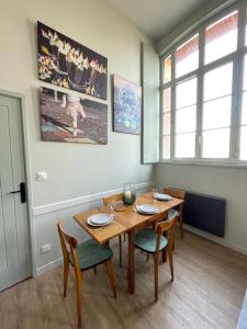 a dining room with a wooden table and chairs at "C'est la Récré" Place de parking privative Centre ville in Dieppe