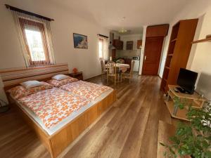 a bedroom with a bed and a living room at Hellasz Apartman in Gyula