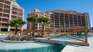 a resort with a wooden bridge over a pool at Sonoran Sun Ground Floor - 104-W in Puerto Peñasco