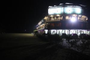 un gran edificio con luces encendidas por la noche en Pakistan Club Inn Hotel, en Kalar Goth
