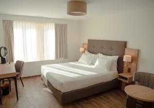 une chambre d'hôtel avec un lit, une table et des chaises dans l'établissement Auberge Le Relais, à Chavannes-de-Bogis