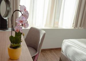 un vase de fleurs sur une table avec une chaise dans l'établissement Auberge Le Relais, à Chavannes-de-Bogis