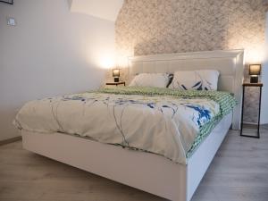 a white bed in a bedroom with two lamps at Melion Historical Center Apartment in Sibiu