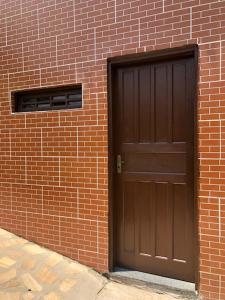 a brown door on the side of a brick building at Pesque pague pousada do Carlinho in Pinheiral