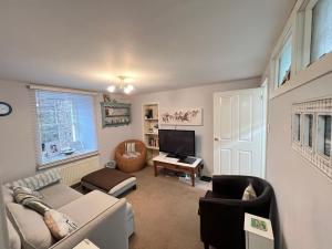 a living room with a couch and a tv at Quaint, cosy bolt hole in Cellardyke in Cellardyke