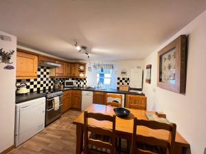a kitchen with a wooden table and a dining room at Quaint, cosy bolt hole in Cellardyke in Cellardyke
