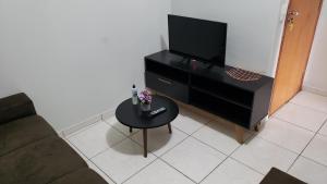 a living room with a tv and a coffee table at Apto aconchegante no Guará II,próximo ao aeroporto in Brasilia