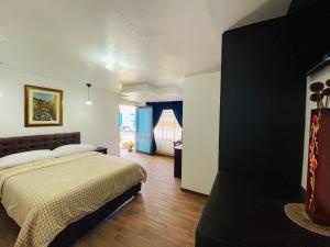 1 dormitorio con 1 cama y 1 habitación con ventana en Hotel Montecarlo en Riobamba