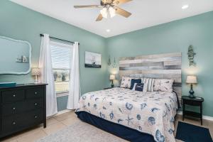 a bedroom with a bed and a ceiling fan at Sea Glass Cottage in Crystal Beach
