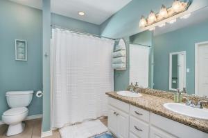 une salle de bain avec deux lavabos et un WC dans l'établissement Sea Glass Cottage, à Crystal Beach 18 autres photos