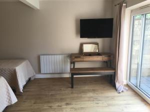 a room with a desk and a television on a wall at Bond End Road Annex Upton St Leonards - Ideal for Cheltenham Races in Matson