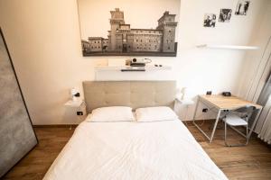 Habitación pequeña con cama y escritorio. en La dolce vita en Ferrara