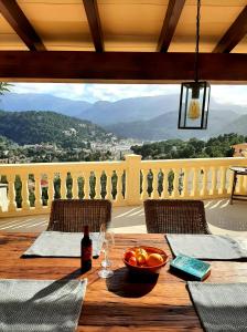 a table with a bowl of fruit and a bottle of wine at Casa Sol with private terrace, garden, pool, beautiful view in Port de Soller