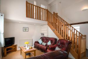 a living room with a couch and a staircase at Summer Cottage located in rural Welsh Countryside, beautiful mountain views, Ideal for Snowdonia walkers in Gwytherin