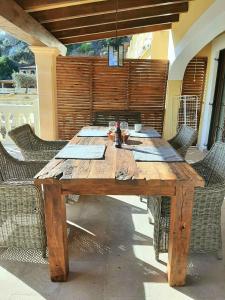 drewniany stół z krzesłami wokół niego na patio w obiekcie Casa Sol with private terrace, garden, pool, beautiful view w mieście Port de Soller