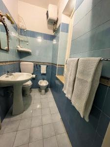 a bathroom with a toilet and a sink with towels at casa delle rose in Isola delle Femmine