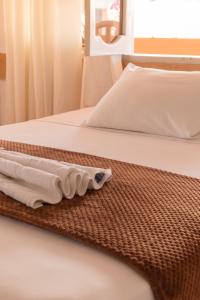 Una cama con dos toallas encima. en Hotel Crossman en Puerto Ayora