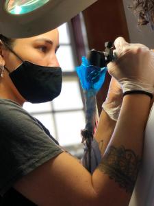 Una donna con una maschera e si fa un tatuaggio. di - Casa Pitanga - Acomodação lindíssima pertinho da Igreja do Rosário a Ouro Preto