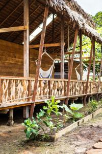 a porch of a house with a hammock in it at Casa Azul Reserva Amazonica in Leticia