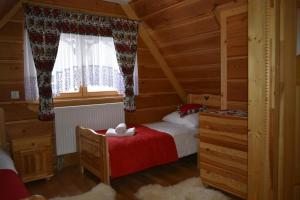 a small bedroom with a bed and a window at Domek Góralski POD LASEM in Witów