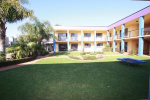 an apartment building with a large yard with a picnic table at Nautilus Apartments Merimbula in Merimbula