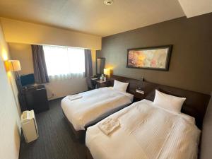 a hotel room with two beds and a window at Lagunasuite Shinyokohama in Yokohama