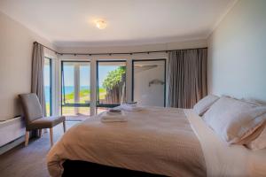a bedroom with a bed with a view of the ocean at Oceana Heights Paradise - Beautiful 2 bdrm self contained apartment in Tairua