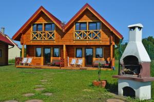 a large wooden house with a fireplace in the yard at House in Niechorze near Baltic Sea Beach in Niechorze