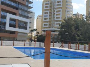 uma piscina no meio de alguns edifícios em Elite Residence 14D Praia da Rocha em Portimão