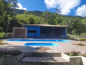 a villa with a swimming pool and a house at Rancho Pôr Do Sol in Arapeí