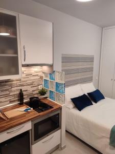 ein kleines Schlafzimmer mit einem Bett und einem Schreibtisch mit einer Küche in der Unterkunft Estudio Madrid Norte 2 in Madrid