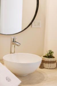 a white bowl sink on a counter with a mirror at El Castaño Apart in Potrerillos +37 photos