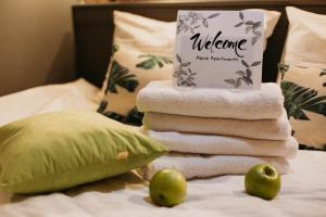 a pile of towels and apples on a bed at Apartment ALPINE URBAN GARDEN in Saint Petersburg