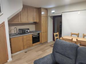 a kitchen and a living room with a couch and a table at Casa dos Conchos 2 in Sabugueiro