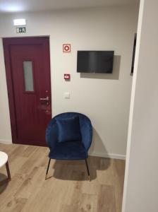 uma cadeira azul sentada num quarto com uma porta em Casa dos Conchos 2 em Sabugueiro