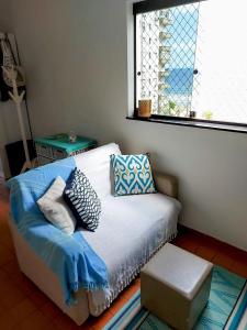 a bed with pillows on it in a room with a window at Vista&Aconchego in Santos
