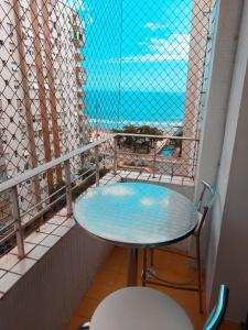 una mesa en un balcón con vistas al océano en Vista&Aconchego en Santos