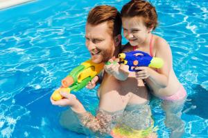 a man and a girl playing in a swimming pool at Family Resort Hotel Милоо in Loo