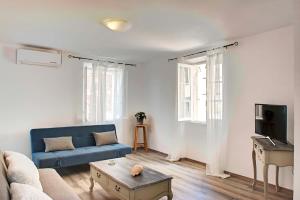 a living room with a blue couch and a table at Casa di Roza in Corfu