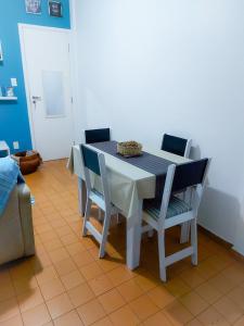 una mesa con 4 sillas, una mesa blanca, una mesa y un sillón en Vista&Aconchego en Santos